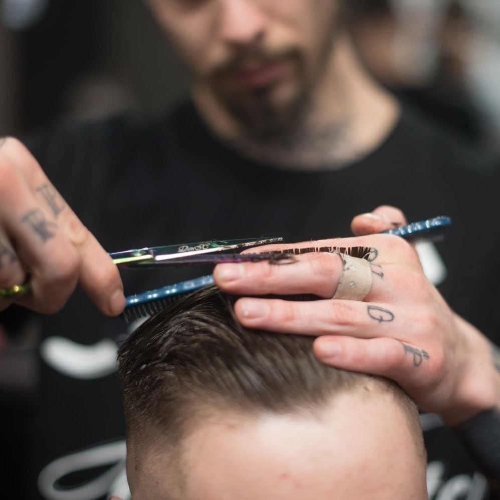 online barber school student Photo by Dmitry Zvolskiy: https://www.pexels.com/photo/man-cutting-the-hair-on-the-person-sitting-on-the-chair-1805600/